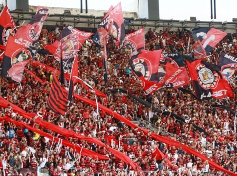 Fans passionately cheer with flags at a football match in Maracanã Stadium, Rio de Janeiro. Fans passionately cheer with flags at a football match in Maracanã Stadium, Rio de Janeiro.