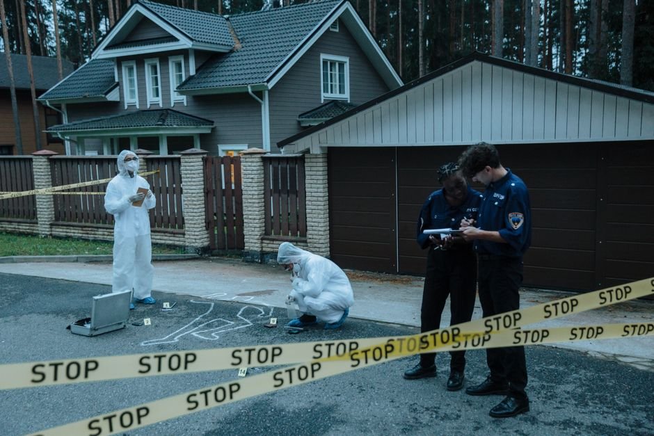 Jammu and Kashmir: Three Detained in Shopian, Explosives Seized Forensic team investigates suburban crime scene with police officers and evidence markers.