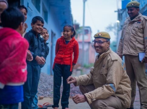 Friendly police officers interacting with smiling children in a street in Uttar Pradesh, India. Friendly police officers interacting with smiling children in a street in Uttar Pradesh, India.