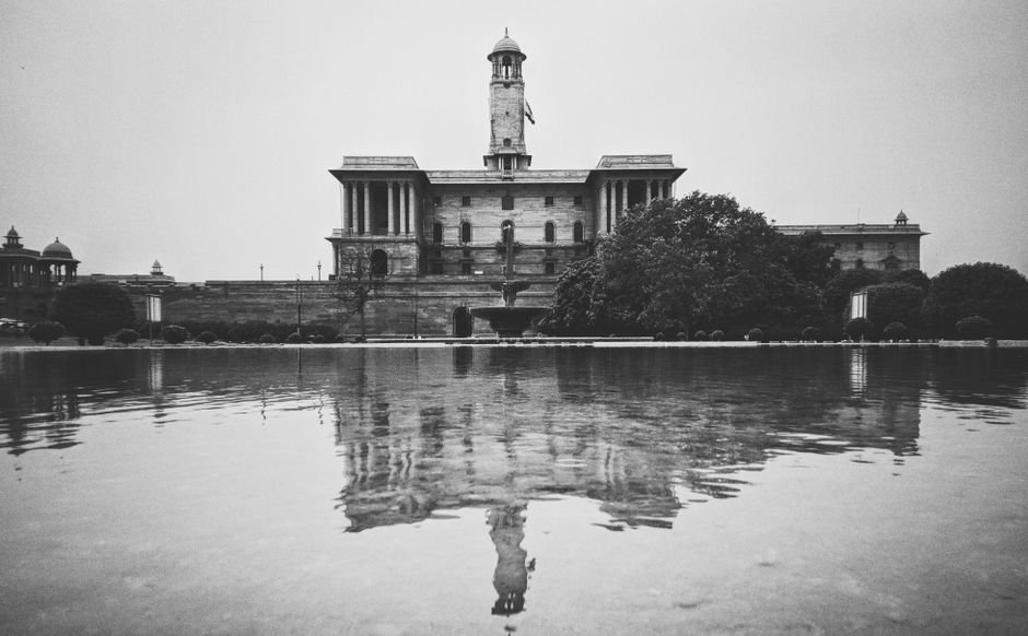 Tamil Nadu CM Accused of Failing Constitutional Morality by DMK MP A. Raja Grayscale photo of a historic building reflecting on water in New Delhi.