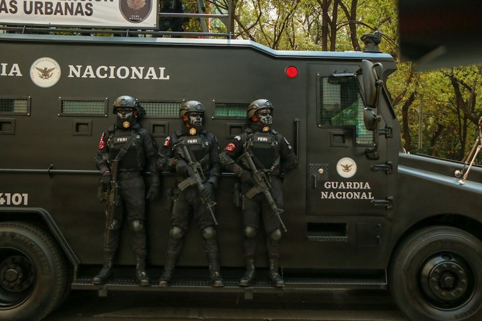 Suspicious Drone Activity Over Meerut Cantonment Prompts Security Alert and Investigation Guardia Nacional officers in tactical gear stand alert beside an armored vehicle.