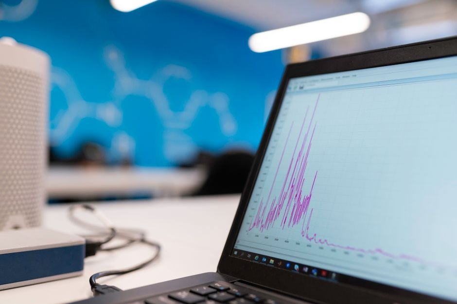 Freshworks Eyes $1 Billion ARR Milestone Amidst Growing Enterprise Traction Laptop displaying data analytics graph in a modern office setting, symbolizing growth and technology.