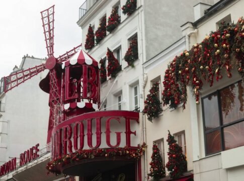 Moulin Rouge in Paris festively decorated with Christmas ornaments and red windmill. Moulin Rouge in Paris festively decorated with Christmas ornaments and red windmill.