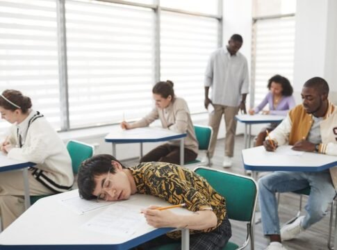 Students in a classroom taking an exam, showcasing diversity and focus.