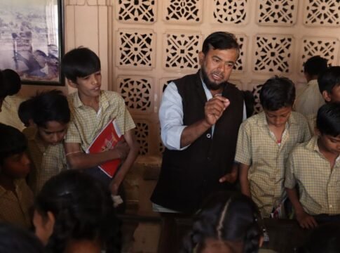 Teacher guiding attentive students during an interactive indoor lesson, fostering education.
