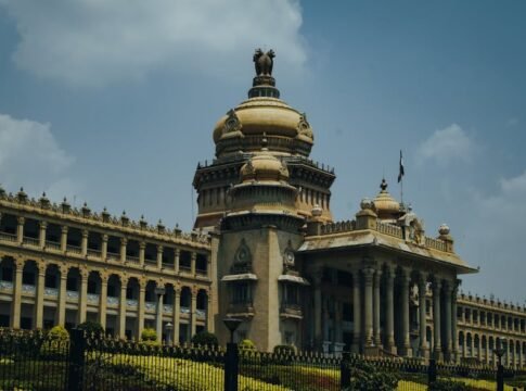 The majestic Vidhana Soudha in Bengaluru captured under a vibrant blue sky.
