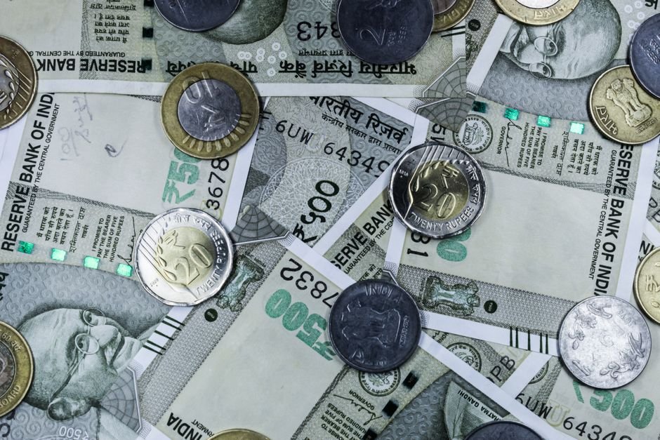 Invest UP and Invest India Forge Alliance to Bolster Investment and FDI in Uttar Pradesh Top view of various Indian rupee banknotes and coins, highlighting financial themes.