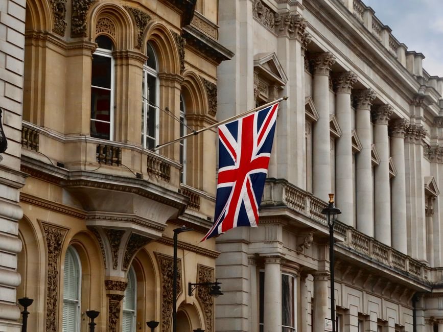 UK Prime Minister Considers Social Media Ban for Under-16s Union Jack flag flying on a historic London building facade.