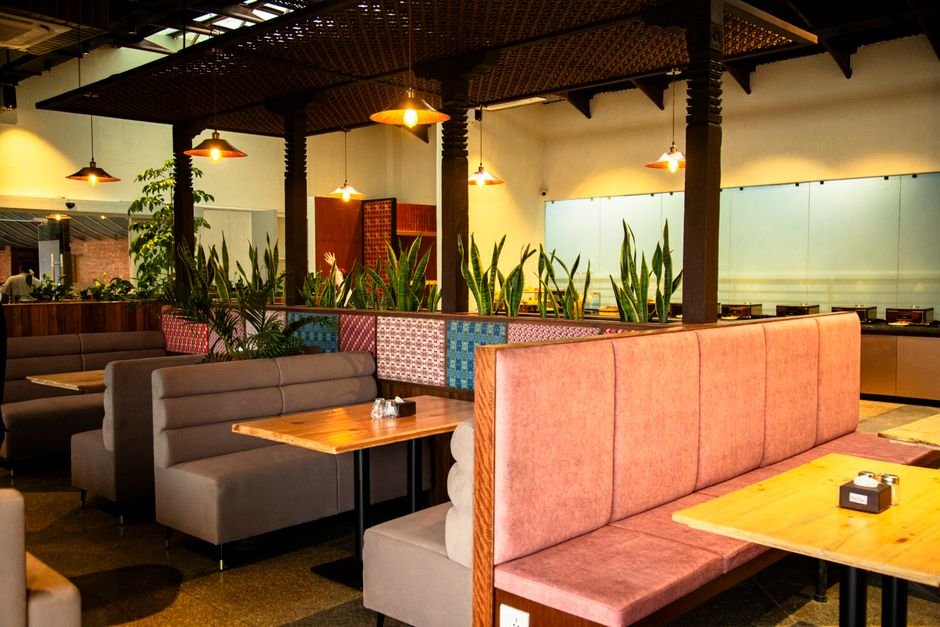Mumbai’s Historic Udupi Restaurants: Sharda Bhavan and Amba Bhavan Serve Generations Warm, inviting restaurant interior showing empty booths and vibrant decor.