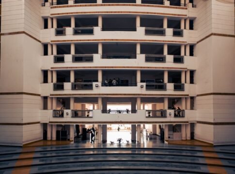 Wide view of a modern university building in Dehradun, India, highlighting architectural design and stairs.