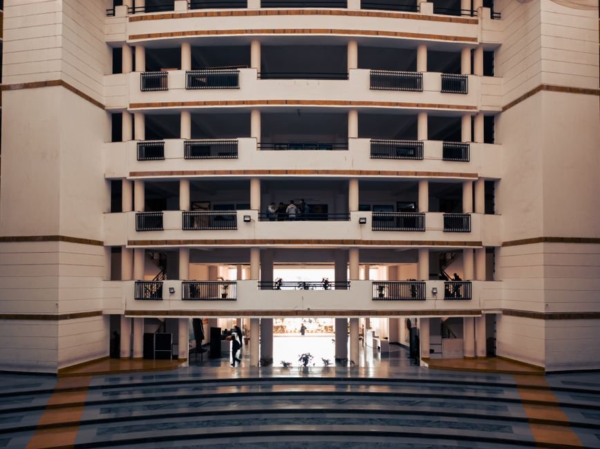Punjab’s Noor Singla Secures All India Rank 1 in CA Final Examination Wide view of a modern university building in Dehradun, India, highlighting architectural design and stairs.