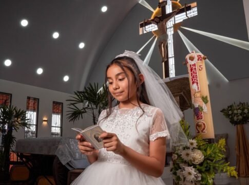 Young girl in white dress reading during communion ceremony in church. Young girl in white dress reading during communion ceremony in church.