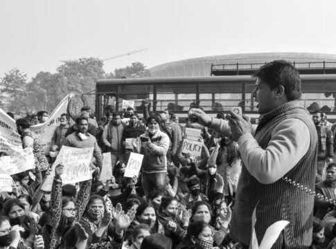 A black and white image capturing a protest crowd with a passionate speaker addressing the gathering. A black and white image capturing a protest crowd with a passionate speaker addressing the gathering.
