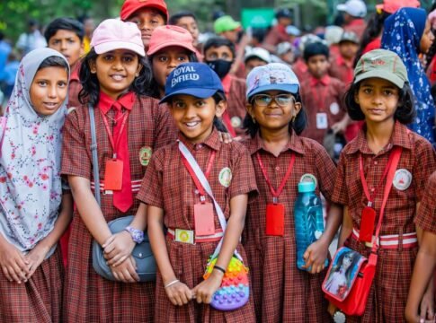 A cheerful group of school children smiling outdoors in uniforms with ID cards. A cheerful group of school children smiling outdoors in uniforms with ID cards.