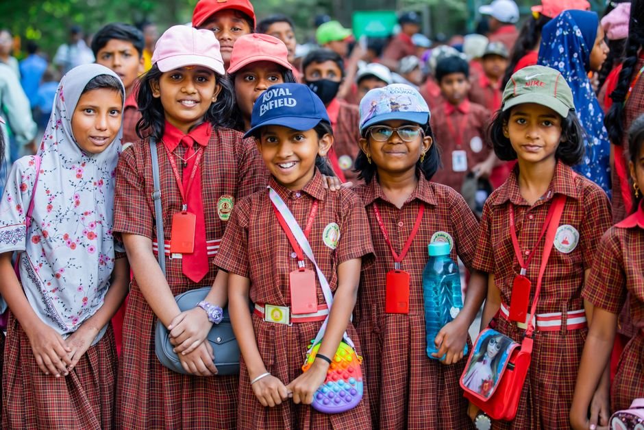 Bengaluru Students Protest as Teachers Diverted to SIR Duty, Leaving Classes Understaffed A cheerful group of school children smiling outdoors in uniforms with ID cards.