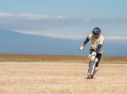 A cricket player batting outdoors on a sunny day, showcasing athletic skill. A cricket player batting outdoors on a sunny day, showcasing athletic skill.
