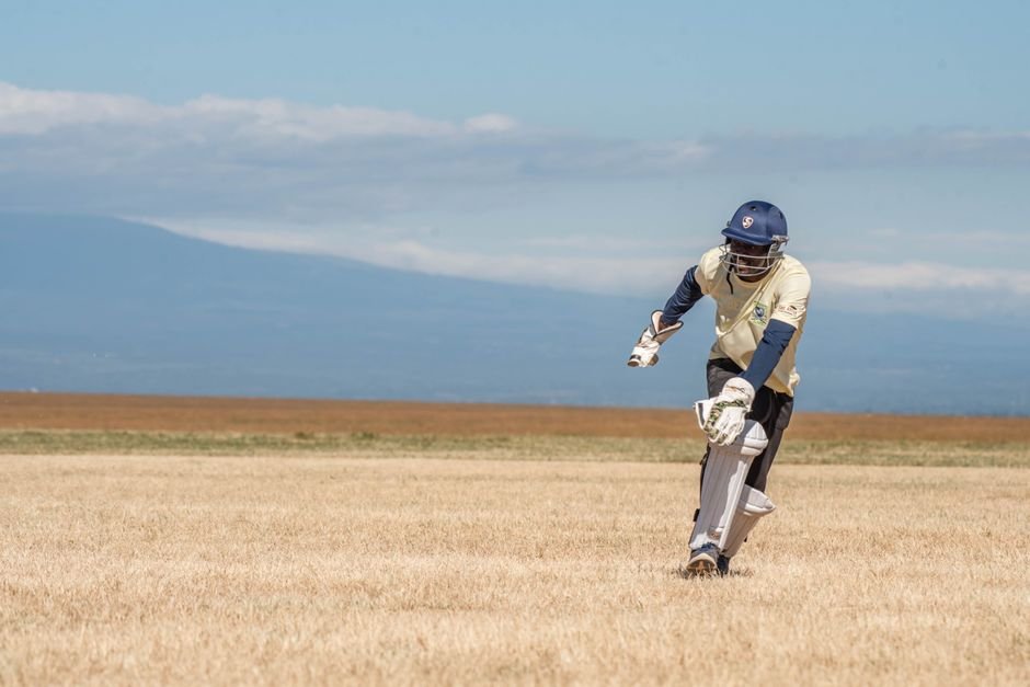 Jammu and Kashmir: Cricketer Collapses and Dies During Match in Doda A cricket player batting outdoors on a sunny day, showcasing athletic skill.