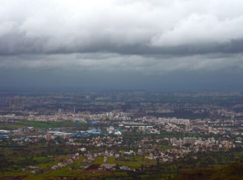 A dramatic aerial view of Pune, India, showcasing urban sprawl under stormy clouds. A dramatic aerial view of Pune, India, showcasing urban sprawl under stormy clouds.