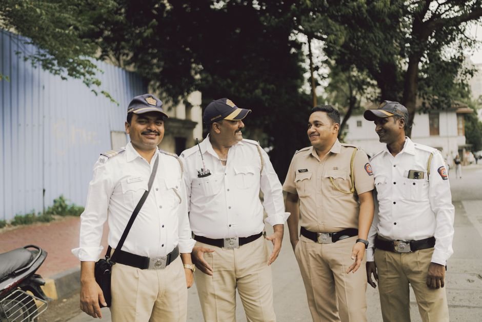 Mumbai Police Dispatch WhatsApp Notices to Hundreds Following NEET Protests A group of friendly police officers smiling and standing on a street in Mumbai, India.