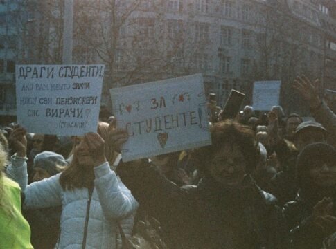 A large group of students holding signs during a peaceful protest outdoors.