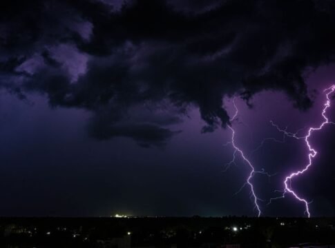 A powerful thunderstorm with dramatic lightning strikes over a city at night in India. A powerful thunderstorm with dramatic lightning strikes over a city at night in India.