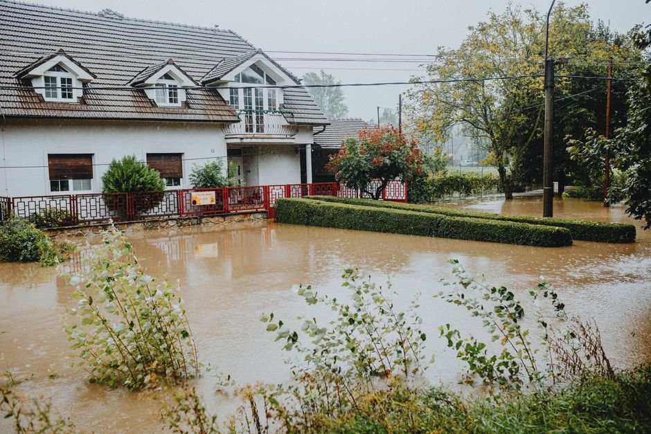 Jammu Region Gripped by Heavy Rainfall, Death Toll Climbs to 23; High Alert Persists A suburban house surrounded by floodwaters after heavy rain, showing impact of natural disaster.