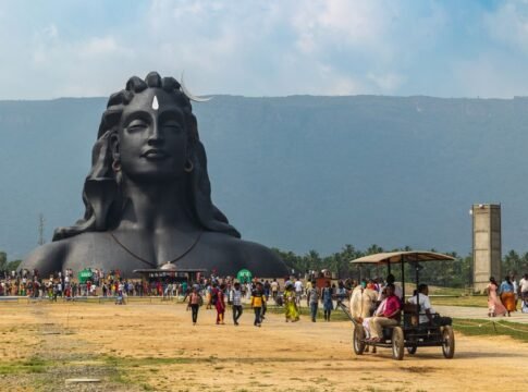 A vibrant scene at the Adiyogi Shiva statue with visitors and lush mountain backdrop in Booluvampatti, India. A vibrant scene at the Adiyogi Shiva statue with visitors and lush mountain backdrop in Booluvampatti, India.