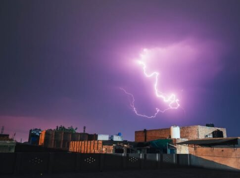 A vivid lightning bolt illuminates the night sky over Faisalabad, Pakistan, casting dramatic shadows on city rooftops. A vivid lightning bolt illuminates the night sky over Faisalabad, Pakistan, casting dramatic shadows on city rooftops.