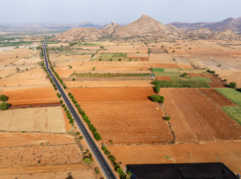 Aerial perspective of agricultural fields and a road intersecting the farmland landscape. Aerial perspective of agricultural fields and a road intersecting the farmland landscape.