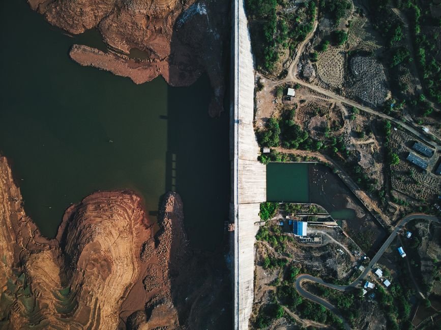 Pune Dams Reach Near Capacity Amid Heavy Rainfall; Water Release into Mutha River Prompts Alert Aerial shot of Temghar Dam showcasing the river, rock formations, and lush surroundings.
