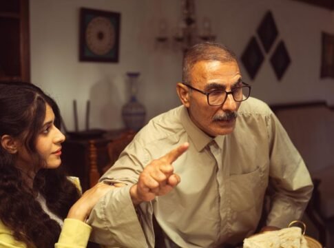 An older man and young woman having an intense discussion in a cozy living room setting. An older man and young woman having an intense discussion in a cozy living room setting.