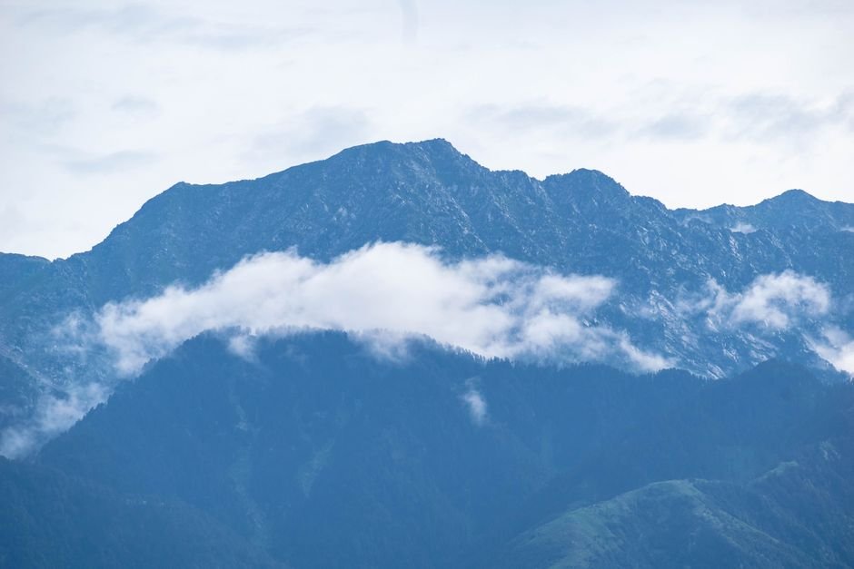 Jammu and Kashmir Administration Mandates Prior Permission for Bhaderwah Adventure Activities Captured mountain peaks with floating clouds and fog on a serene day.