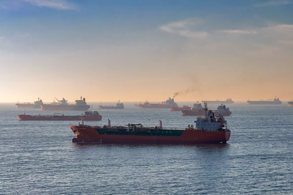 Oil Prices Surge Amid Renewed US Blockade on Iran Cargo ships and oil tankers on the Bosporus strait, capturing global trade and maritime logistics at sunset.