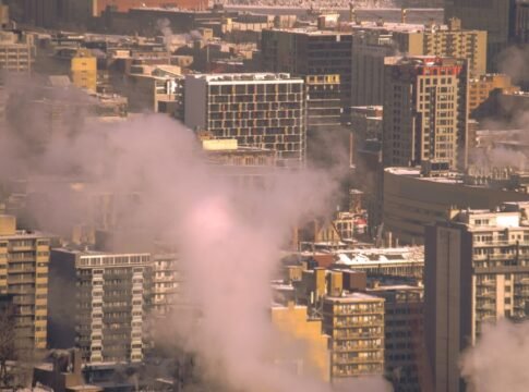 City skyline with smoke rising from buildings, showcasing urban winter scene in Montreal. City skyline with smoke rising from buildings, showcasing urban winter scene in Montreal.
