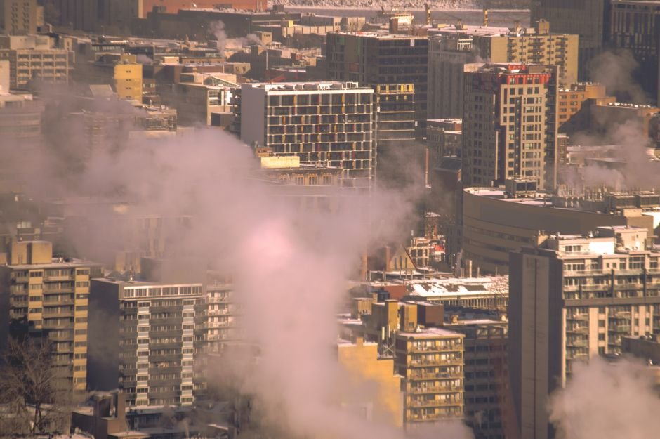 Bengaluru Launches Heat Collective to Combat Rising Urban Temperatures City skyline with smoke rising from buildings, showcasing urban winter scene in Montreal.