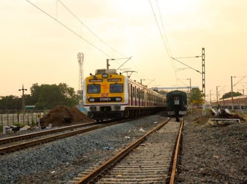 Commuter train travels through a railway station under the warm sun. Commuter train travels through a railway station under the warm sun.