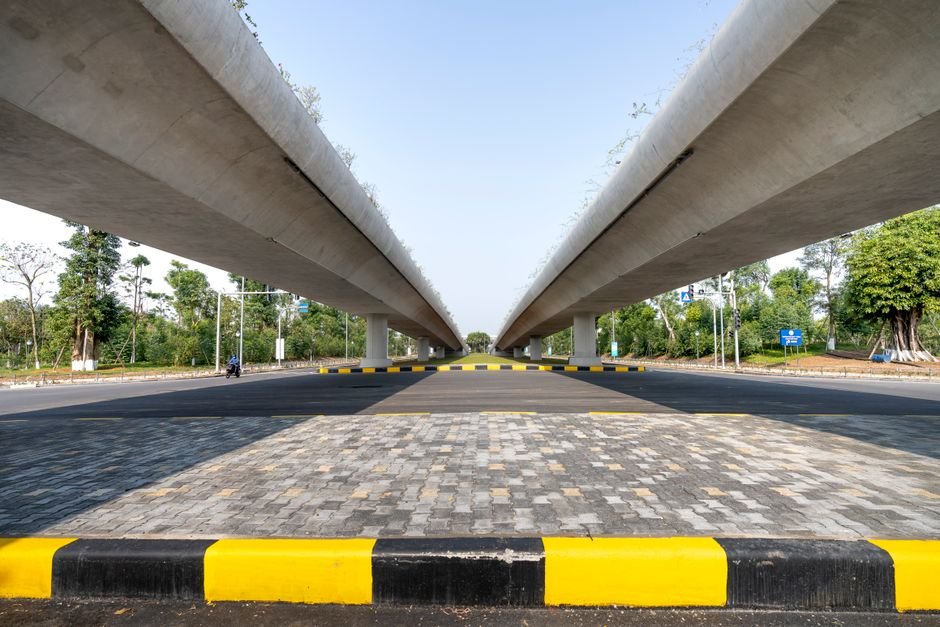 Pune Traffic Congestion to See 30% Reduction with New Mega Road Projects, Claims Maharashtra CM Concrete elevated highways over asphalt road between lush greenery in suburb under blue sky