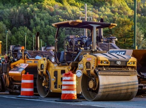 Construction machinery and vehicles on site with road rollers and cones. Construction machinery and vehicles on site with road rollers and cones.
