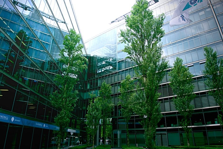Tamil Nadu: ‘Tamizhar 4.0’ Business Conclave Kicks Off in Chennai to Foster Global Entrepreneurship Contemporary glass architecture with trees reflecting in the facade on a bright day.