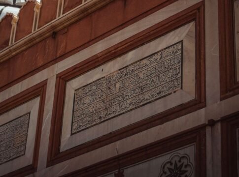 Detailed view of Arabic inscriptions on a historic wall, showcasing intricate architecture. Detailed view of Arabic inscriptions on a historic wall, showcasing intricate architecture.