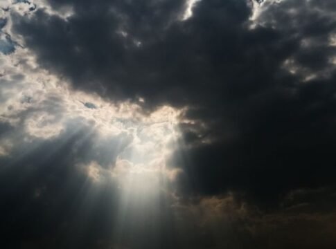 Dramatic sky with sun rays piercing through dark clouds, creating a celestial atmosphere. Dramatic sky with sun rays piercing through dark clouds, creating a celestial atmosphere.