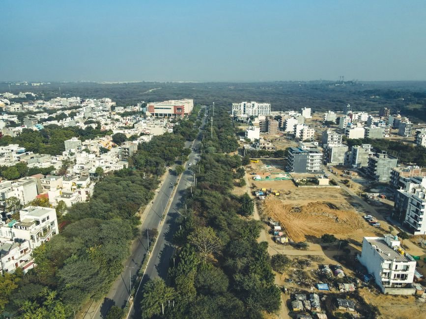Gurgaon Homebuyers Secure Dream Homes After 15-Year Legal Struggle Drone shot capturing the expansive urban landscape and development in Gurugram, India.