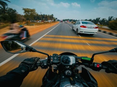Dynamic POV view of a biker riding on a bustling Indian highway in Bengaluru.