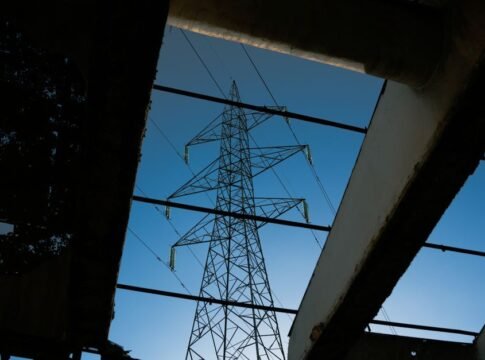 Electric tower framed by industrial ruins against a blue sky. Electric tower framed by industrial ruins against a blue sky.