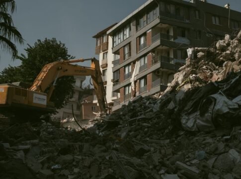 Excavator removing rubble from a collapsed building area in Antakya, Türkiye.