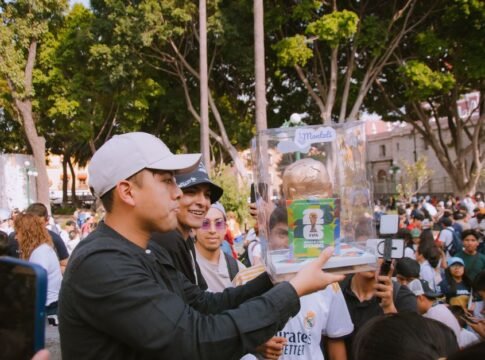 Group of people celebrating with a FIFA World Cup trophy replica in a vibrant outdoor setting. Group of people celebrating with a FIFA World Cup trophy replica in a vibrant outdoor setting.