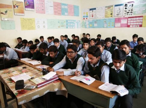 High school boys attentively listening and taking notes in a crowded classroom. High school boys attentively listening and taking notes in a crowded classroom.