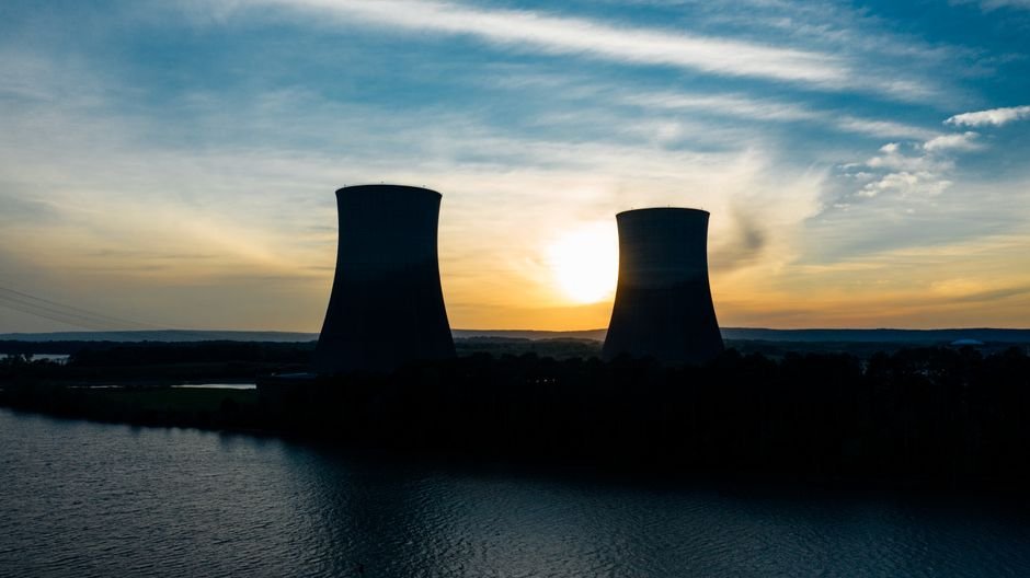 Kudankulam Nuclear Plant Data Leaked on Dark Web Amid Ransomware Attack Identical cooling tower silhouettes on power plant near rippled river under colorful cloudy sky at sundown