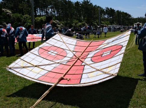 People preparing a large bamboo kite at a Japanese kite festival in Hamamatsu.