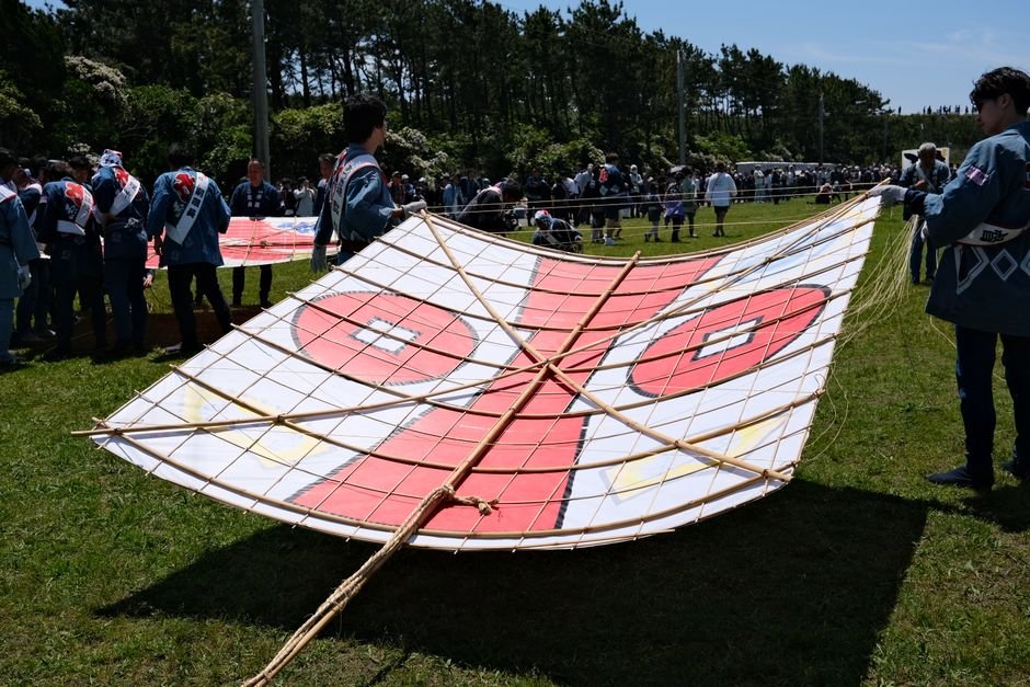 People preparing a large bamboo kite at a Japanese kite festival in Hamamatsu.